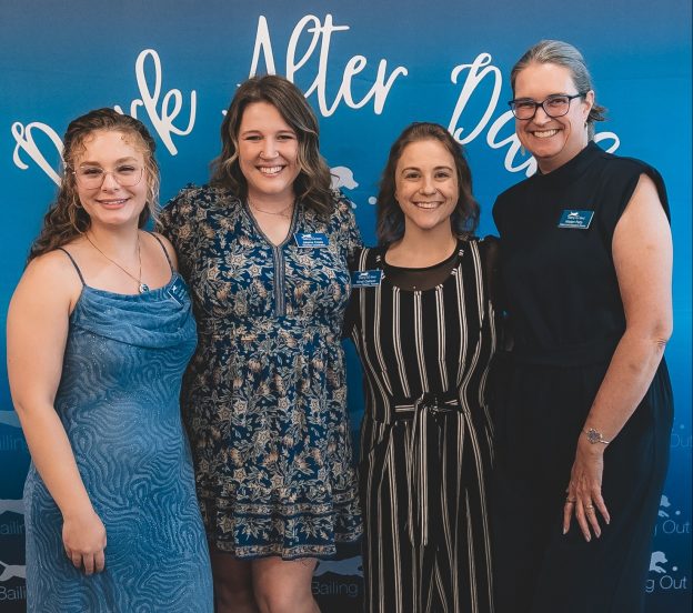 Four women smiling at event